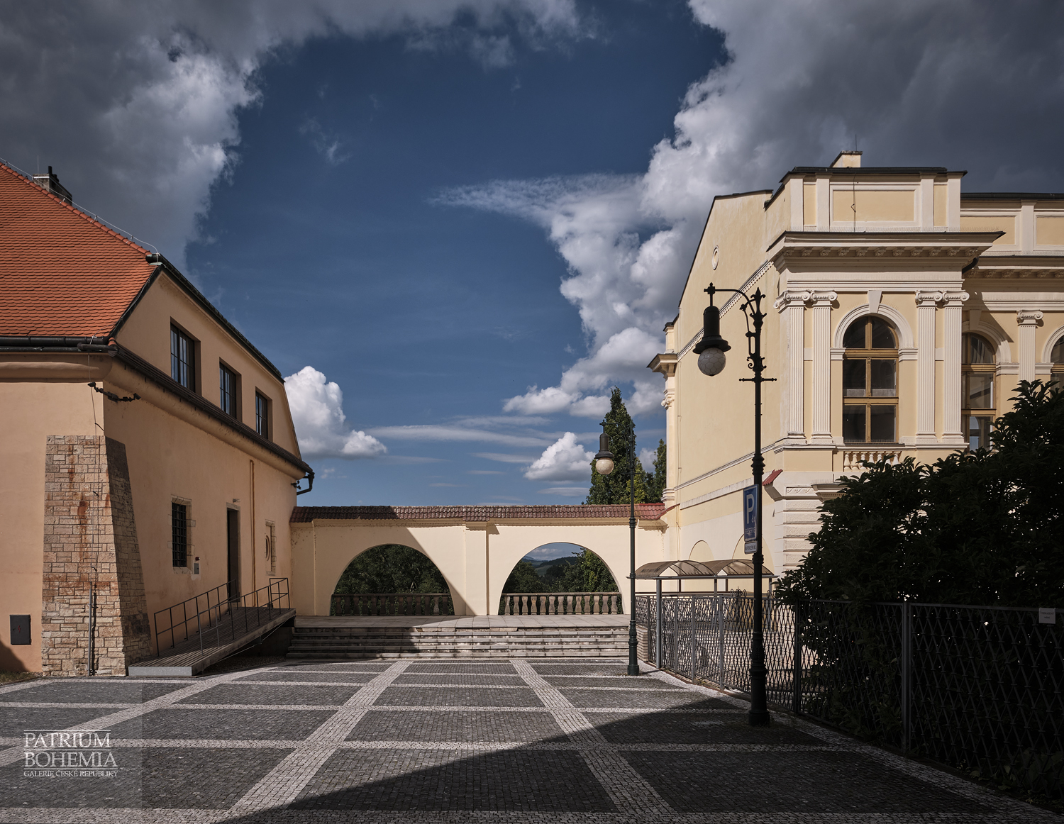 On the left side Benedikt Rejt gallery, in the middle a terrace with arches, on the right is the rear wing of the town hall. Louny.